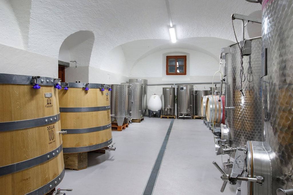 Cantina con volte bianche, tini in rovere marchiati Sella e serbatoi in acciaio inox